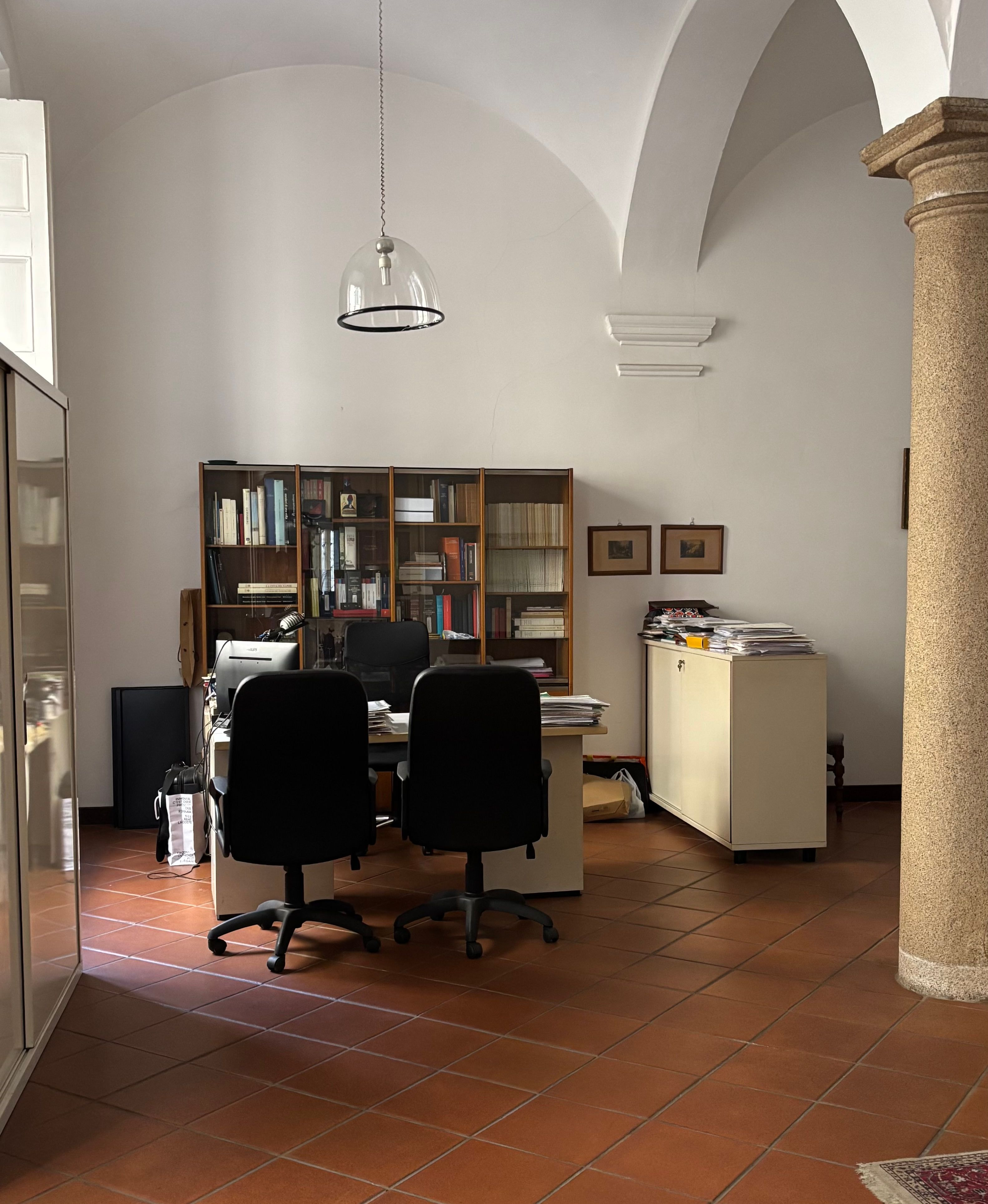 Sala dello Studio sotto le volte a crociera, con la colonna in granito e la libreria